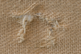 close-up of canvas with torn threads