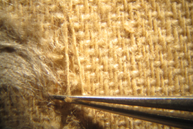 re-aligning the fibers with a pair of tweezers